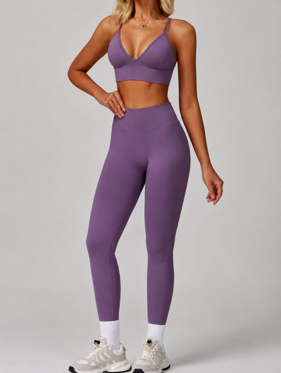 Woman wearing the ContourFlex Seamless Top & Leggings in Purple, standing in a three-quarter pose with one hand resting on her waist.
