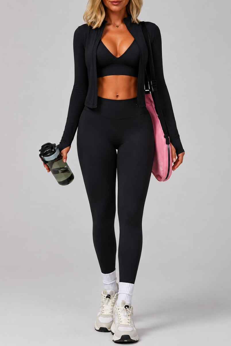 Model wearing the Black ContourFlex Three-Piece Set with top, jacket and leggings in a back three-quarter pose.