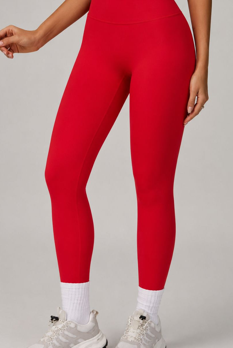 Red ContourFlex leggings shown in a front-detail pose, highlighting the smooth, sculpting fit.