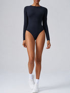 Woman wearing Aether Sculpting Long Sleeve Bodysuit in black, shown in a front pose with a sculpting fit.