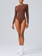 Woman wearing Aether Sculpting Long Sleeve Bodysuit in coffee, shown in a front pose with a sculpting fit.