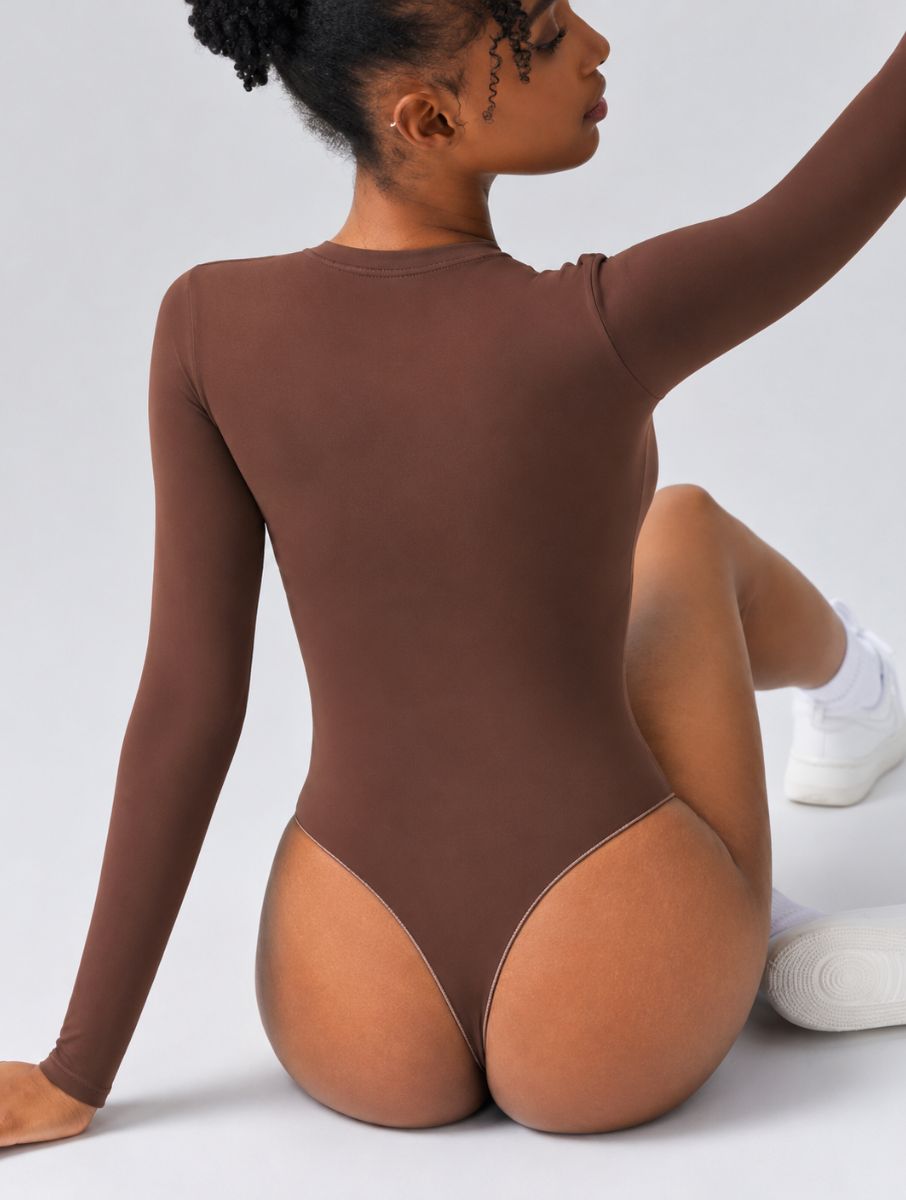 Woman wearing Aether Sculpting Long Sleeve Bodysuit in coffee, shown in a seated back pose with a sculpting fit.