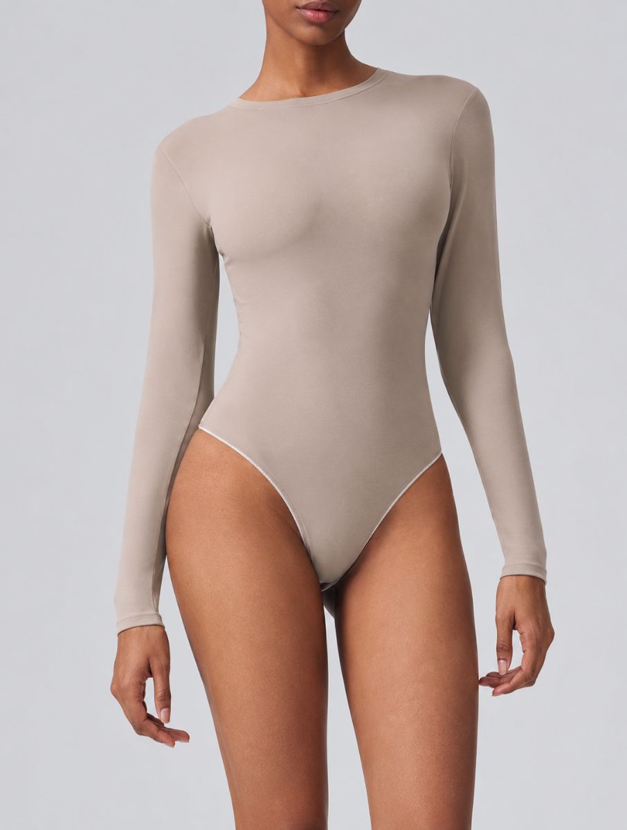 Woman wearing Aether Sculpting Long Sleeve Bodysuit in khaki, shown in a front pose with a sculpting fit.