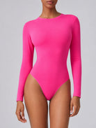 Woman wearing Aether Sculpting Long Sleeve Bodysuit in pink, shown in a front pose with a sculpting fit.