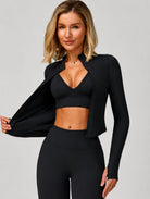 Model wearing the Black ContourFlex Three-Piece Set with top, jacket and leggings, posing with the jacket open.