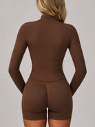 Back view of a woman wearing the ContourFlex Three-Piece Set in dark coffee, featuring a fitted jacket and shorts, standing with her hands behind her back.
