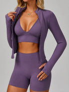 Front view of a woman wearing the ContourFlex Three-Piece Set in purple, featuring a sports bra, fitted jacket, and shorts, posing with one hand holding the jacket collar.