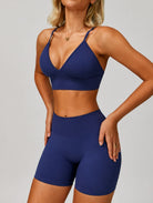 Woman wearing the ContourFlex Seamless Top & Shorts in Navy Blue, posing in a front-angle stance with hands on her hips.