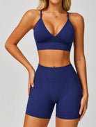 Woman wearing the ContourFlex Seamless Top & Shorts in Navy Blue, standing in a front-facing pose with one hand on her hip.