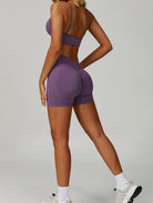 Woman wearing the ContourFlex Seamless Top & Shorts in Purple, posing in a back-angle stance showcasing the seamless fit.