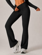 Woman wearing High-Waist Flared Yoga Leggings in black, shown in a front pose with a flared-leg design.