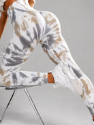 Seamless Tie-Dye Scrunch Leggings in green, shown in a seated side pose with a tie-dye pattern.