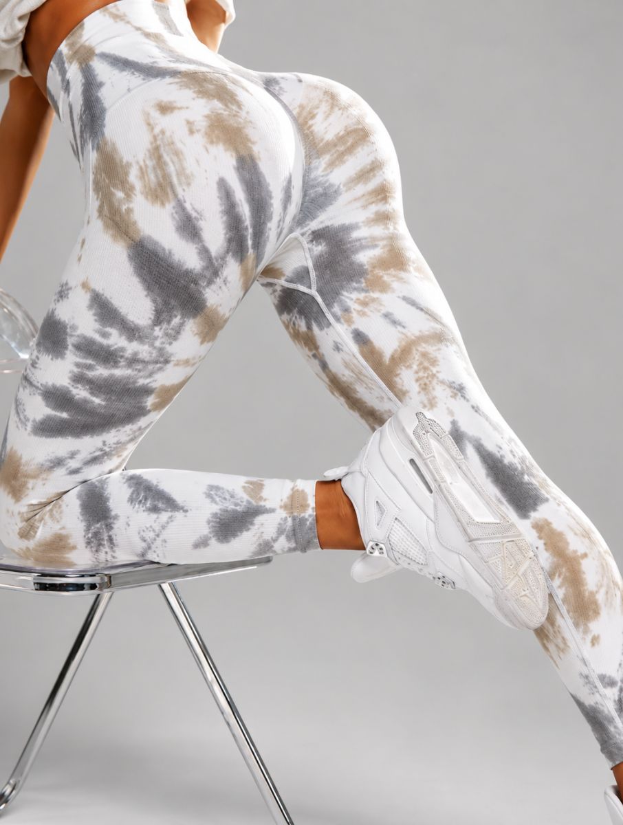Seamless Tie-Dye Scrunch Leggings in green, shown in a seated side pose with a tie-dye pattern.